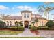 Stately Mediterranean home featuring a tile roof, manicured landscaping, and a grand entrance with double doors at 8814 Southern Breeze Dr, Orlando, FL 32836