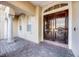 Close-up of elegant double doors featuring decorative wood carvings, complemented by classic architectural details and lush landscaping at 8814 Southern Breeze Dr, Orlando, FL 32836