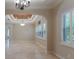 Bright living room with neutral walls, shutters, marble floors, and chandelier with unique ceiling decor at 8814 Southern Breeze Dr, Orlando, FL 32836