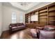 Living room features custom built-in shelves, hardwood floors, and a leather sofa at 8814 Southern Breeze Dr, Orlando, FL 32836