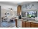 Bright kitchen with stainless sink, wooden cabinetry, connecting to living space with lots of natural light at 9568 Muse Pl, Orlando, FL 32829