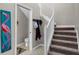 Carpeted staircase with white banister near a half bath and flamingo art at 9568 Muse Pl, Orlando, FL 32829