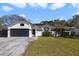 Charming single-story home featuring a black garage door, white siding, and manicured front lawn at 10562 Bridlewood Ave, Orlando, FL 32825