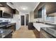 Well-appointed kitchen featuring dark cabinets, a farmhouse sink, and stainless steel appliances at 10562 Bridlewood Ave, Orlando, FL 32825