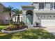 Charming home featuring a well-manicured lawn and inviting front entry with a beautiful garden bed at 112 Tate Ct, Orlando, FL 32828