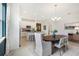 Cozy dining area with large table, white chairs, pendant light, and view into the modern kitchen at 1134 Clay Blvd, Tavares, FL 32778