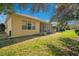 Spacious backyard showing the home's exterior, manicured lawn, and mature landscaping at 117 Cupania Ct, Groveland, FL 34736