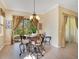 Elegant dining area featuring a stylish chandelier, patio view and modern wood-look floors at 117 Cupania Ct, Groveland, FL 34736