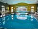 Bright indoor pool with a volleyball net and natural light in a well-appointed room at 117 Cupania Ct, Groveland, FL 34736