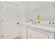 Bright laundry room featuring a white washer and dryer, with a shelf providing storage space at 117 Cupania Ct, Groveland, FL 34736