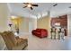 Comfortable living room featuring modern floors, a red sofa, and a cozy recliner at 117 Cupania Ct, Groveland, FL 34736