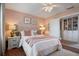 This bedroom features wood floors, a bed with blush accents, and a built-in bookcase with white cabinets at 11735 Whitewing Ct # 11735, Orlando, FL 32837