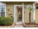 Welcoming front entry with a charming exterior, a small palm tree, and lovely landscaping at 11735 Whitewing Ct # 11735, Orlando, FL 32837