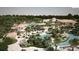 Aerial view showcases resort-style community pool with lush landscaping and amenity buildings at 1304 Sea Pines Way, Davenport, FL 33896