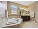 A bright bathroom with a corner tub, double sinks and a decorative tile backsplash at 1304 Sea Pines Way, Davenport, FL 33896