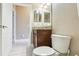 A half bathroom with a wood vanity, granite countertop, and neutral wall color at 1304 Sea Pines Way, Davenport, FL 33896