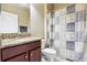 A half bathroom with wood cabinets, granite countertops, and a shower and tub combo at 1304 Sea Pines Way, Davenport, FL 33896