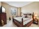 Bedroom with dark wrought iron bed frame, neutral wall color, and views to the outside at 1304 Sea Pines Way, Davenport, FL 33896