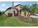 Beautiful landscaped home featuring a tile roof, brick driveway, and mature palm trees at 1304 Sea Pines Way, Davenport, FL 33896