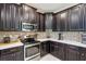 Gourmet kitchen boasts stainless steel appliances and dark wood cabinets at 1304 Sea Pines Way, Davenport, FL 33896