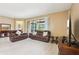 Bright living room with leather sofas, tile flooring, and sliding glass doors to the outdoor patio at 1304 Sea Pines Way, Davenport, FL 33896