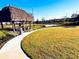 Outdoor seating area with shaded lounge and a beautifully landscaped backyard at 1304 Sea Pines Way, Davenport, FL 33896