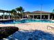 Community pool with a brick pool deck, pergola, umbrellas, and lounge chairs at 1304 Sea Pines Way, Davenport, FL 33896