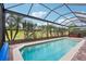 Enclosed pool area surrounded by manicured landscaping and a clear blue pool at 1304 Sea Pines Way, Davenport, FL 33896