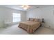 Inviting bedroom with a colorful floral patterned bedspread, ceiling fan and natural light at 134 E Plantation Blvd, Lake Mary, FL 32746