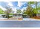 Cozy single-story home with a screened-in porch and covered parking, set against a backdrop of mature trees at 134 E Plantation Blvd, Lake Mary, FL 32746