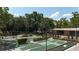 A high angle view shows multiple shuffleboard courts, hedges, and benches near a clubhouse under a canopy of trees at 134 E Plantation Blvd, Lake Mary, FL 32746