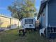 Backyard with trailer and tool bench, nestled between a blue house and a weathered concrete wall at 1404 High St, Leesburg, FL 34748