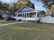 Charming bungalow with welcoming front porch, gray and white paint, and a well-maintained lawn at 1404 High St, Leesburg, FL 34748