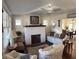 Cozy living room with a white-painted brick fireplace and decorative ceiling fan at 1404 High St, Leesburg, FL 34748