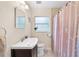 Charming bathroom featuring a decorative shower curtain, window, and stylish vanity at 1531 Norfolk Ave, Winter Park, FL 32789