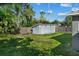 Backyard view showcasing well-maintained landscaping, a storage shed, and a fire pit at 1627 Triangle Ave, Orlando, FL 32806