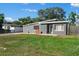 View of well-maintained home featuring a gray exterior, unique roofline, and landscaped front yard at 1627 Triangle Ave, Orlando, FL 32806