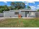 Charming gray home featuring a unique roof line, gray brick accents, and manicured landscaping at 1627 Triangle Ave, Orlando, FL 32806