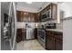 Well-equipped kitchen features granite countertops, dark wood cabinets, and stainless steel appliances at 1627 Triangle Ave, Orlando, FL 32806