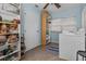 This laundry room includes plenty of storage space in a closet and shelves near modern appliances at 1627 Triangle Ave, Orlando, FL 32806