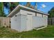 Exterior view of a backyard storage shed with a white door and gray siding and well-kept lawn at 1627 Triangle Ave, Orlando, FL 32806