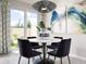 Well-lit dining area next to sliding glass door featuring stylish light fixture and modern art at 16296 Happy Eagle Dr, Clermont, FL 34714