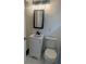 Small bathroom with white tiled walls, black-framed mirror, and white vanity at 1907 Rockwell Rd, Orlando, FL 32808