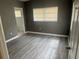 Bedroom features gray paint, wood-look flooring, and a window at 1907 Rockwell Rd, Orlando, FL 32808