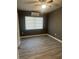 Cozy bedroom with wood-look flooring, a window, and a ceiling fan at 1907 Rockwell Rd, Orlando, FL 32808