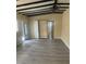 Inviting living room featuring wood-look floors, neutral walls, wood beam ceilings, and a ceiling fan at 1907 Rockwell Rd, Orlando, FL 32808