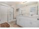 Well-lit bathroom with a double vanity, white cabinetry, and a glass-enclosed shower at 2029 Crystal Bell St, Orlando, FL 32824