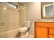 Neutral bathroom featuring a bathtub with tile surround, toilet, vanity with granite countertop and framed mirror at 2734 Cattail Ct, Longwood, FL 32779