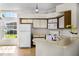 Functional kitchen featuring a breakfast bar, white appliances, and a window overlooking the backyard at 2978 Stillwater Dr, Kissimmee, FL 34743