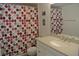 Bathroom with a single vanity, framed mirror, and a shower with colorful patterned curtain at 2989 Viscount Cir, Kissimmee, FL 34747